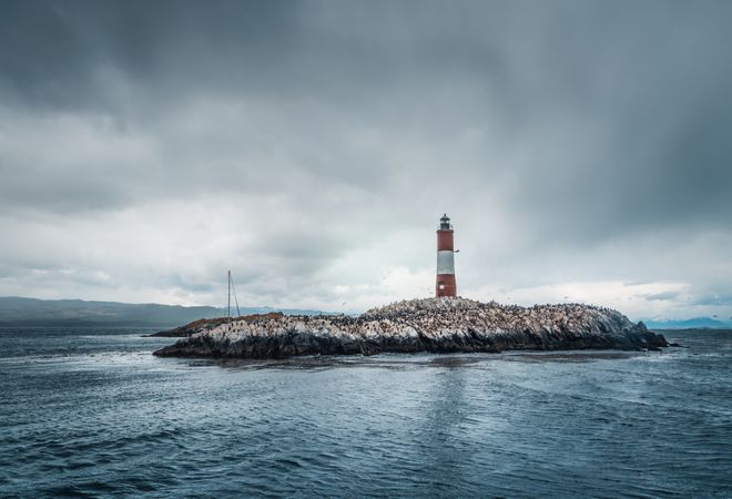 Lighthousein a small island in stormy sea on overcast day