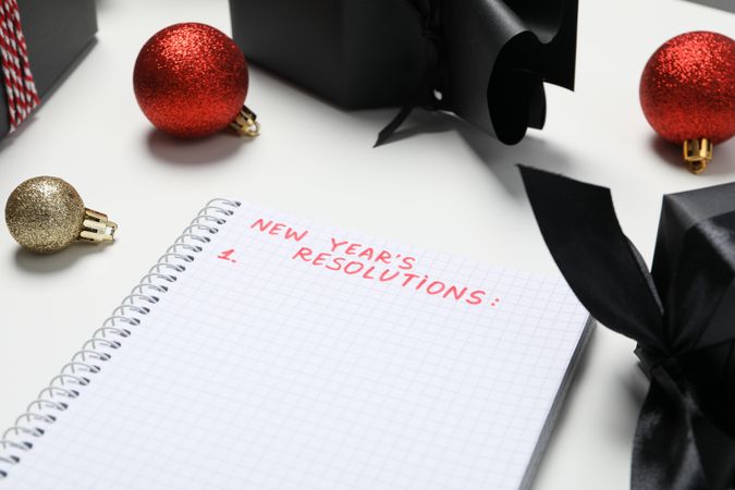 Gift boxes and notepad with list on light background