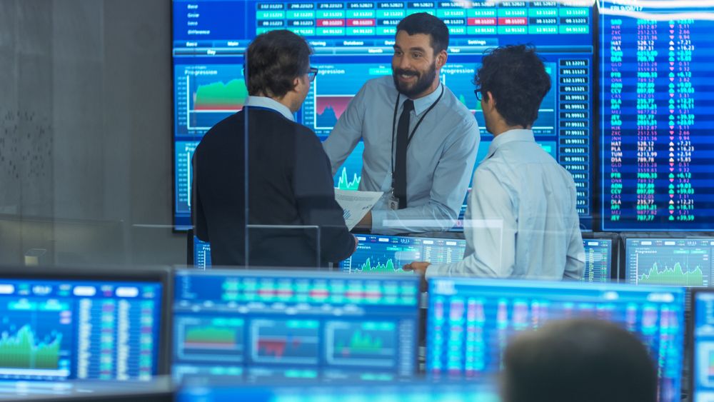 Three Experienced Stock Traders Talking Business. They Work for a Big Stock Exchange Firm.