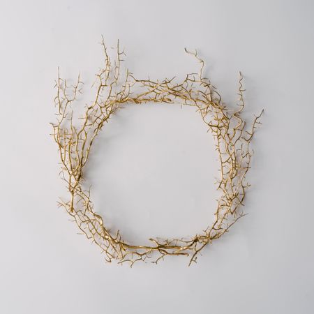 Thorny wreath made of branches on light background
