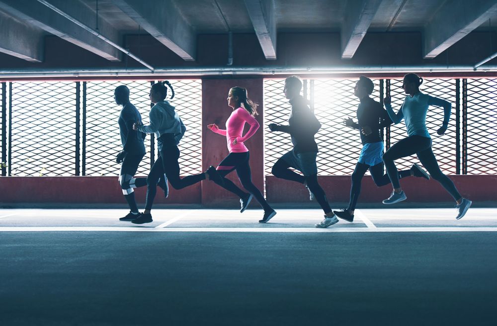 People running backlit by sunlight coming through window