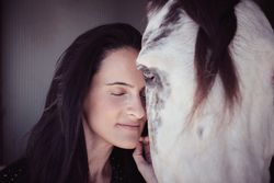 Tender woman caressing white horse
