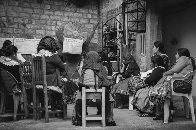 Grayscale photo of indigenous women taking an English class offered by an NGO