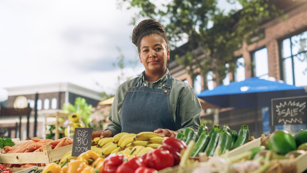 Portrait of a Black Female Working at a Farmers Market Stall with Fresh Organic Agricultural Products.