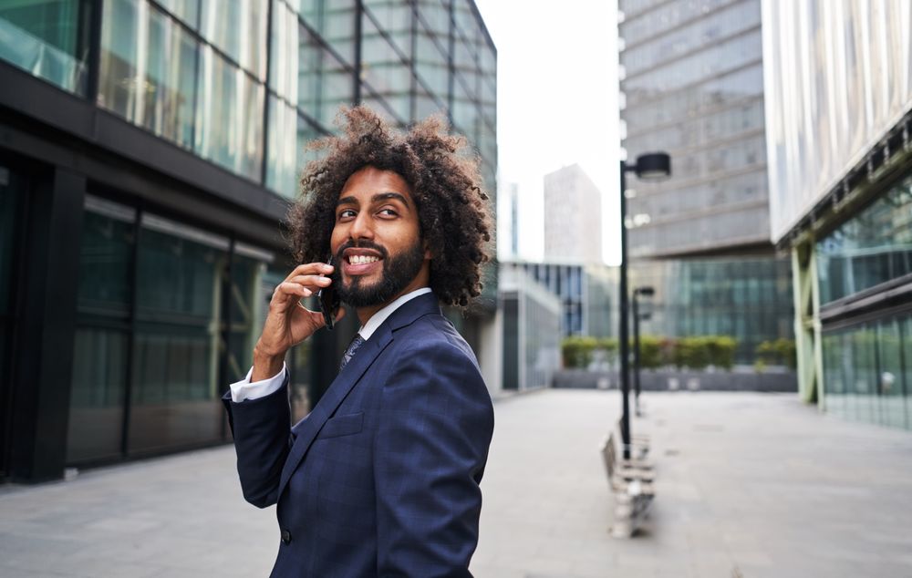 Curly man smiling at street