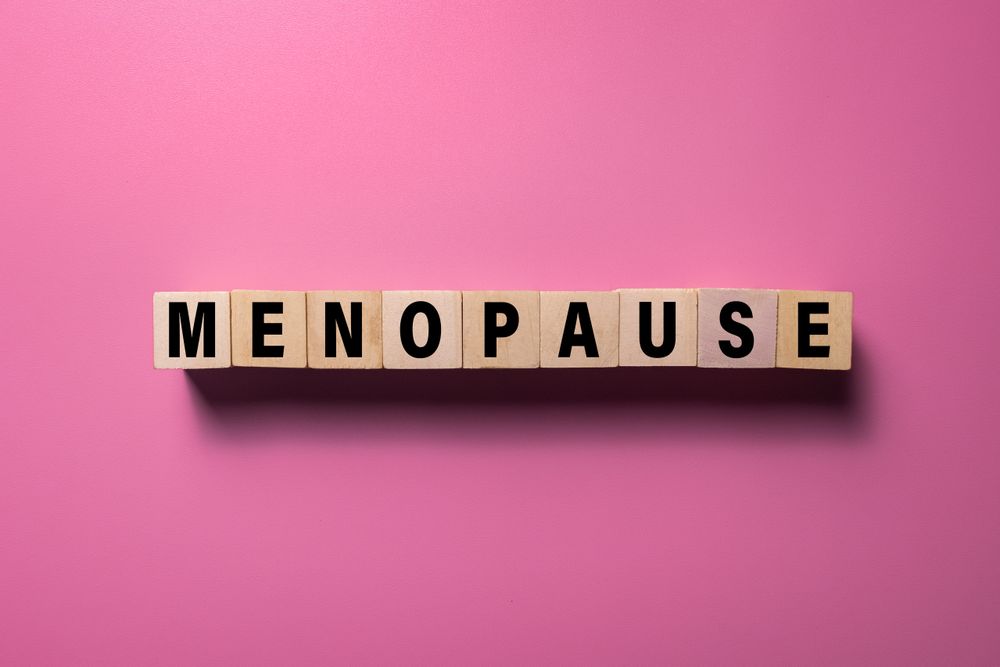 menopause words text on wooden blocks isolated on pink background