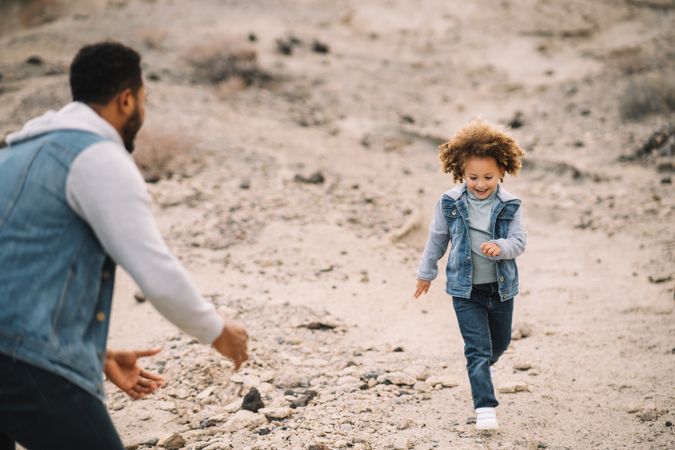 Black father playing with child on ground
