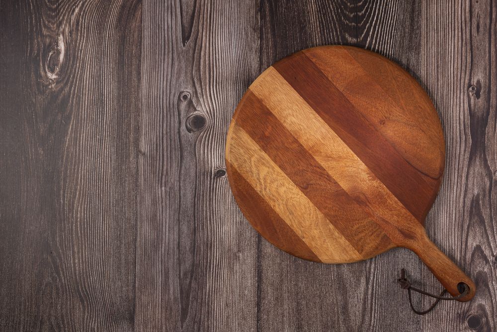 Empty pizza board on rustic wooden table. Top view image.