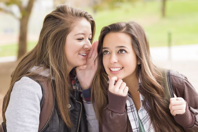 Two Woman Whispering Secrets Outside