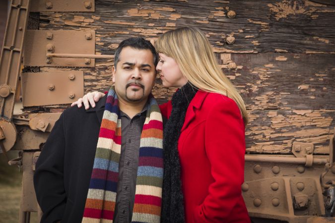 Couple Portrait in Winter Clothing Against Rustic Train