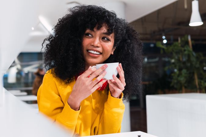 Smiling woman drinking coffee in cafe
