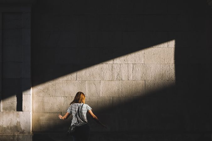 Woman standing in sunlight in dark passage