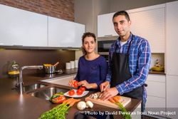 Portrait of couple cutting vegetables for dinner with space for text 5kzaW0