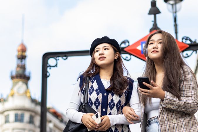 Asian young female friends walking on the street in the city