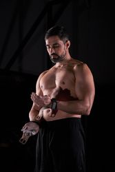 Strong sportsman with wrist belts and magnesium preparing for training