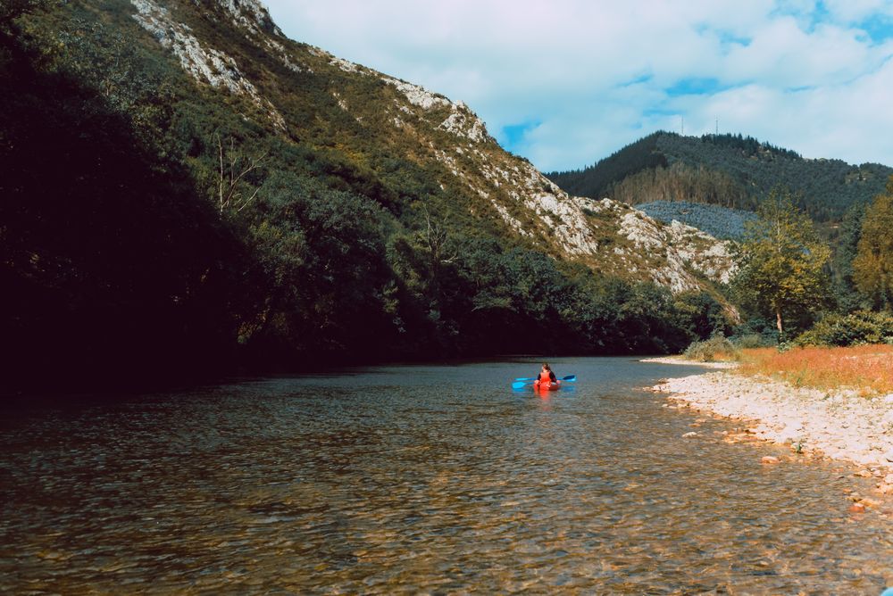Female kayaking with paddle in raised hands