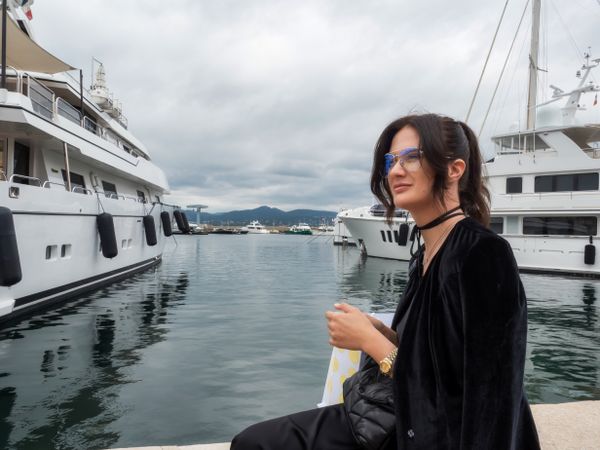 Woman in a sits near moored yachts