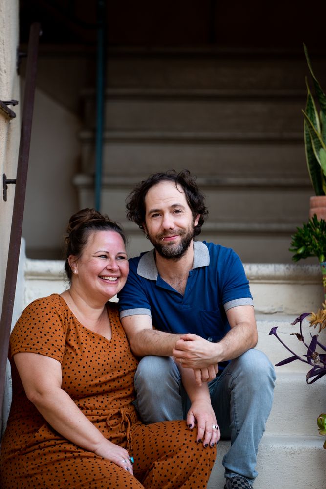 Close up portrait of man and woman holding hands outside on stairs