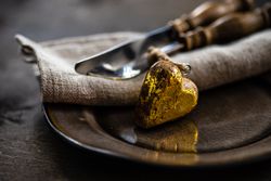 St. Valentine's day concept with golden heart ornament on table setting