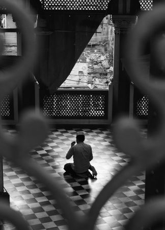 Back view of man sitting a mosque
