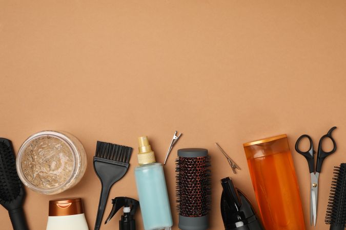 Composition with hairdresser accessories on brown background, space for text