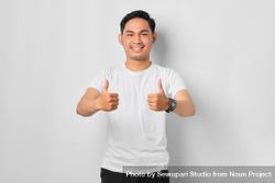 Asian male in grey studio making thumbs up with both hands 5RekB0
