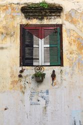Retro window with flowerpots of old building