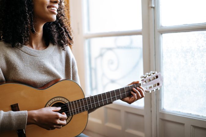 Woman playing guitar in studio