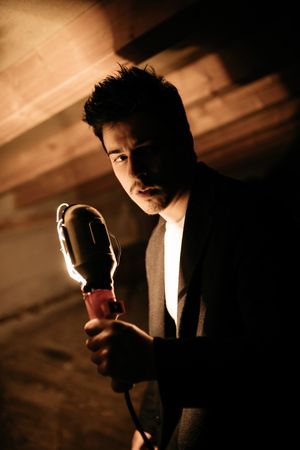 Pensive man with illuminating lamp on garret
