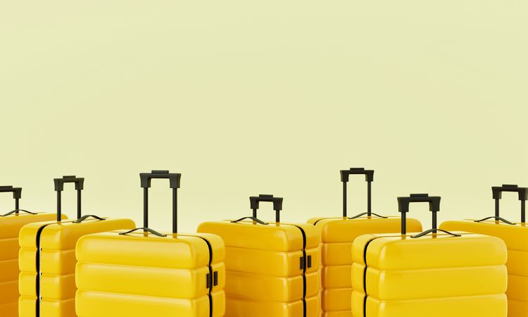 Yellow hard shell roller suitcases arranged on light yellow background