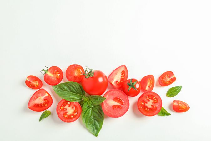 Flat lay composition with fresh cherry tomatoes and basil on studio background, space for text. Ripe vegetables