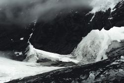 Harsh mountain snowy peak shrouded in fog