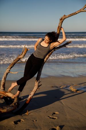 Young woman near twig and water on shore