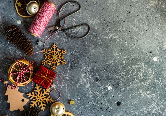 Christmas ornaments and scissors and string on marble table
