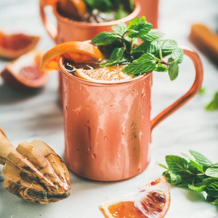 Cocktail in copper mugs with mint garnish and orange slices