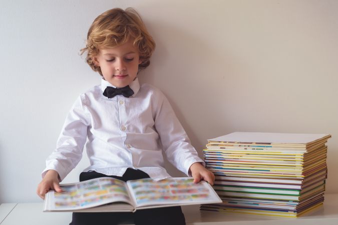 Content boy in suit reading book