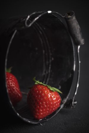 Organic strawberries in a dark bucket