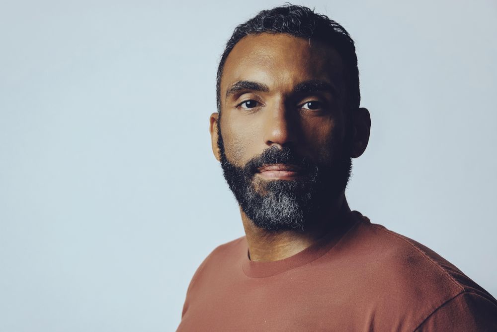 Head shot of calm Black male in grey studio, copy space