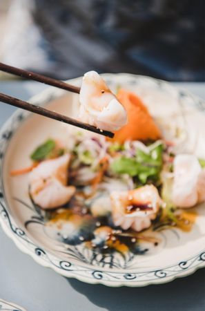 Dumplings pictured between chopsticks