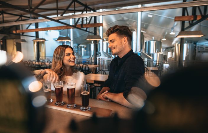 Young couple enjoying craft beers at restaurant