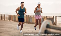 Fitness couple jogging on the sea side promenade 4AzRrE