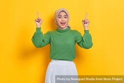 Surprised woman in headscarf holding up both fingers with good idea bYxLY4