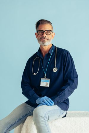 Portrait of a confident male doctor on blue background