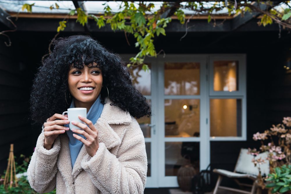 Smiling Black woman with cup of coffee