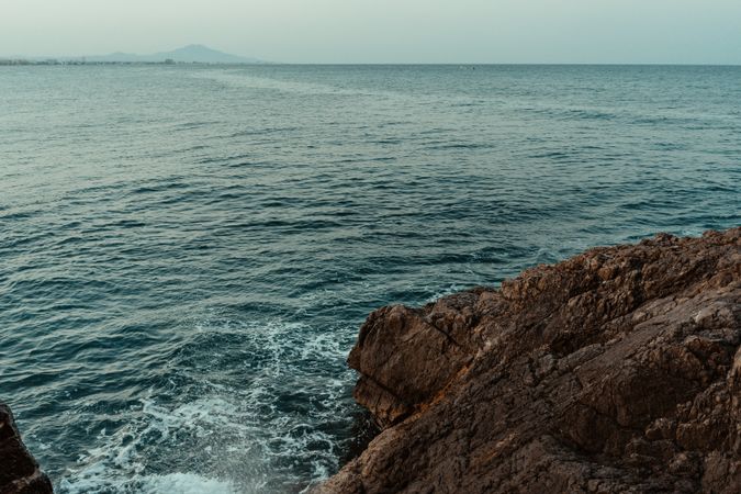 Sea waves hitting rocky cliff