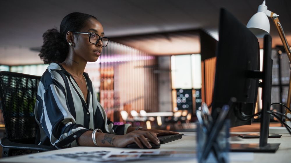 Portrait of a Beautiful Black Woman Using Desktop Computer, Analysing Data, Thinking and Solving Problems.