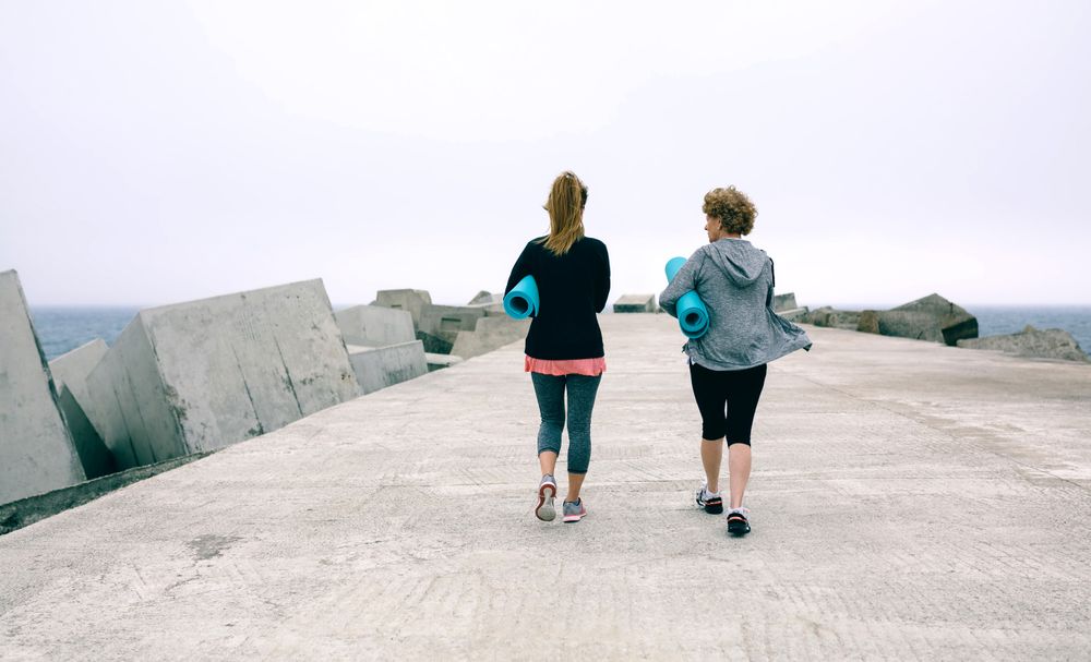 Back view of women walking by sea pier