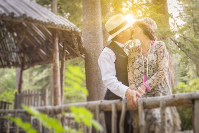 1920s Dressed Affectionate Couple Kissing on Wooden Bridge