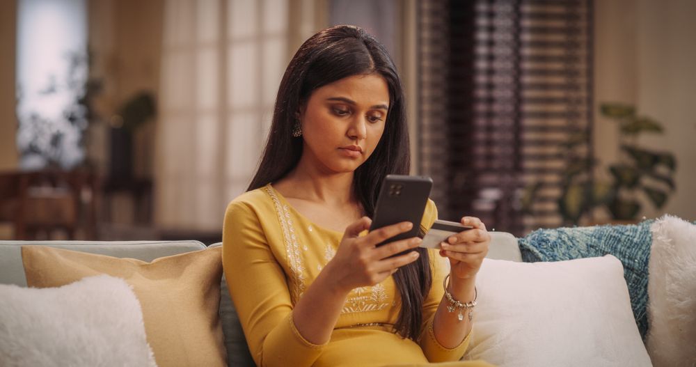 Young Indian Woman Using Smartphone and Credit Card: Doing Online Shopping for Loving Family, Making Secure Transactions