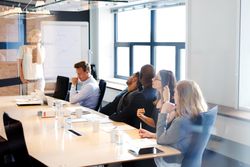 Group of co-workers sitting in boardroom in a meeting